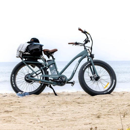 An electric bike on the beach with a bag on the back rack