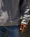 Man wearing gray crew neck sweater made from a blend of organic cotton and recycled polyester.
