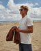 Man on the beach wearing plain white t-shirt
