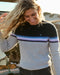 A woman smiling and touching her hair, wearing a striped sweater with a crew neckline, where the stripes feature shades of gray, blue, and purple, and the brand logo 'OK' is visible on the chest.