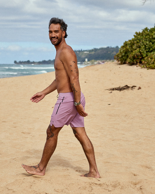 Man wearing purple boardshorts on the beach