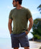 A green crew-neck t-shirt with a front pocket on a man on the beach