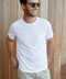 Man wearing plain white t-shirt with wood background