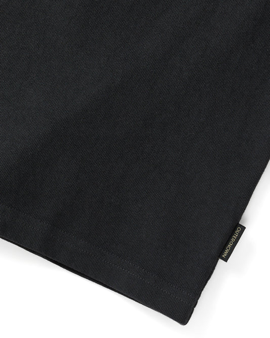 Close up of 'Outerknown' tag on the end of black short sleeve t-shirt