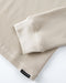 Beige textured fabric with a brand label on a white background