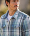 Outerworn plaid blanket shirt close-up: collar, button placket, and chest pocket flaps.