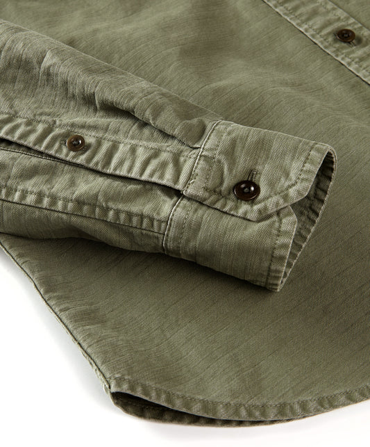 Closeup of a green, long-sleeved utilitarian shirt sleeve