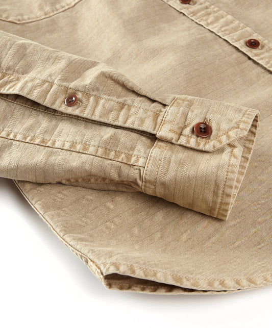 Closeup of sleeve of beige utilitarian shirt