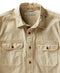 A long-sleeved, button-up, beige utilitarian shirt with chest pockets.