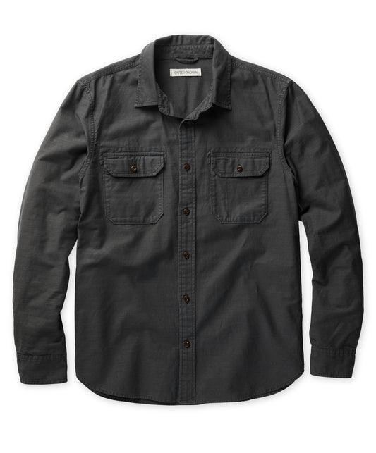 A long-sleeved black shirt with a herringbone texture, featuring a collar, button-up front, and two chest pockets.