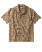 A short-sleeved button-up shirt with a geometric pattern featuring shades of brown and white, natural corozo nut buttons, and a camp collar.