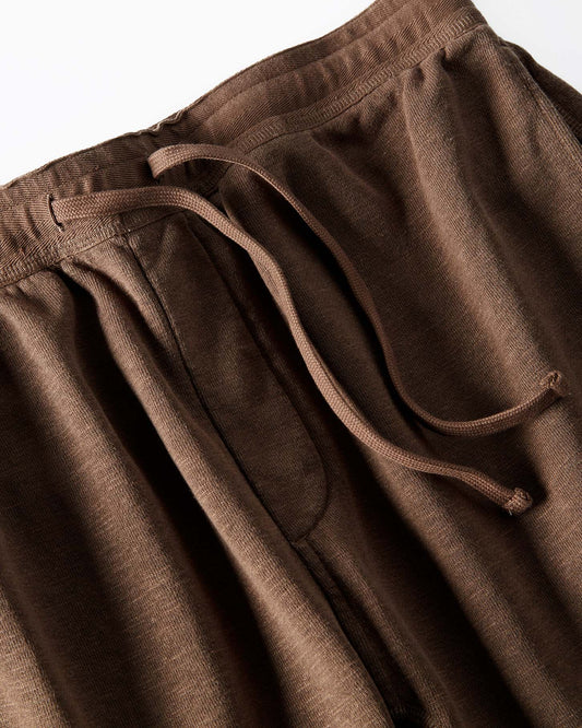 Close-up of brown sweatpants with drawstring waistband on a white background