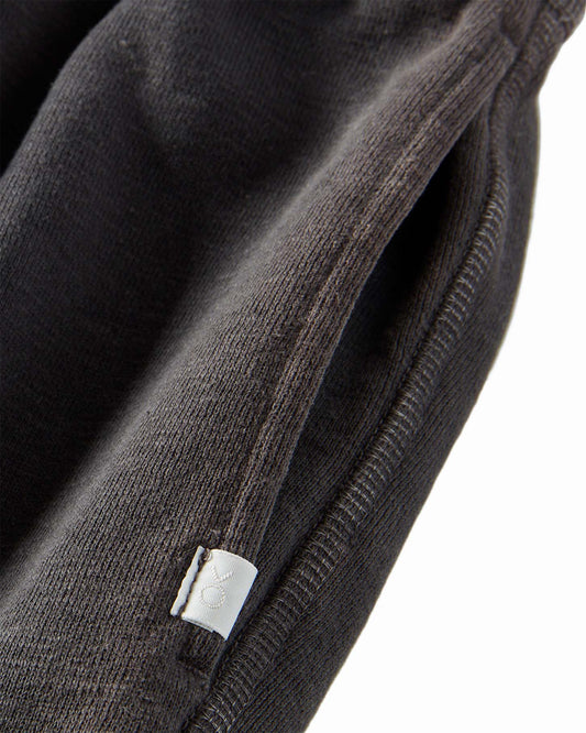 Close-up of black fabric with a brand logo on a white background