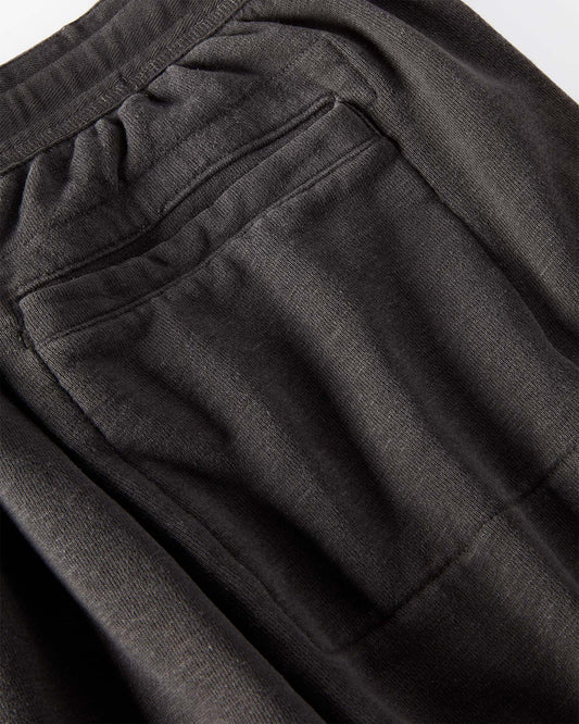 Close-up of black sweatpants with a focus on the back pocket.