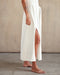 Closeup of bottom half of white sleeveless tank dress 