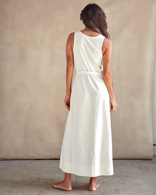Back of woman in a studio wearing a white sleeveless tank dress 