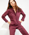 Outerworn plum station jumpsuit detail: chest pocket, zipper placket, and belt tie