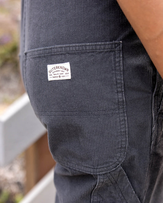 Close-up of a pocket on dark pants with a visible brand label.