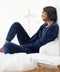 Dark marine blue velour crewneck with matching jogger pants, seated side view