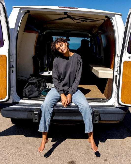 Person sitting inside an open van with a scenic background