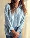Closeup of a woman wearing a blue chambray utility shirt with chest pockets and button closure, paired with high-waisted blue jeans.