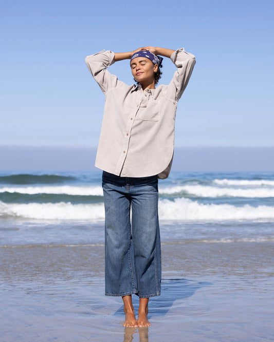 Person standing on a beach with ocean waves in the background