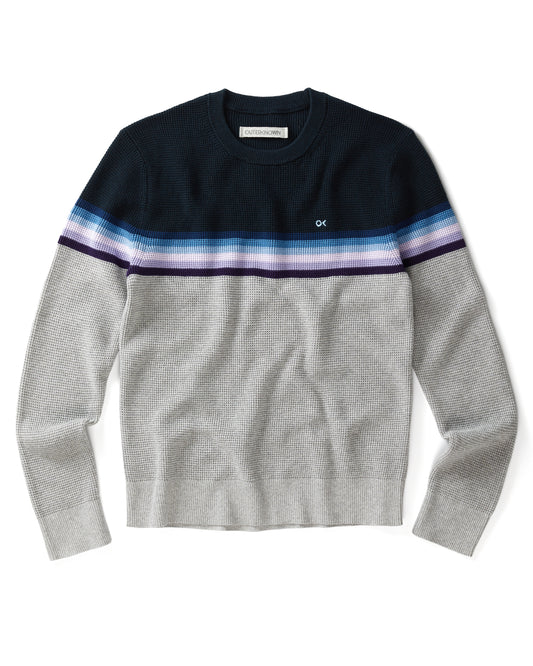 A striped sweater with a crew neckline, where the stripes feature shades of gray, blue, and purple, and the brand logo 'OK' is visible on the chest.