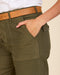 Deep olive utility pants detail: flap pocket, reinforced stitching, and leather belt