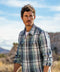 Blue plaid blanket shirt worn open over a white tee, with sleeves rolled up