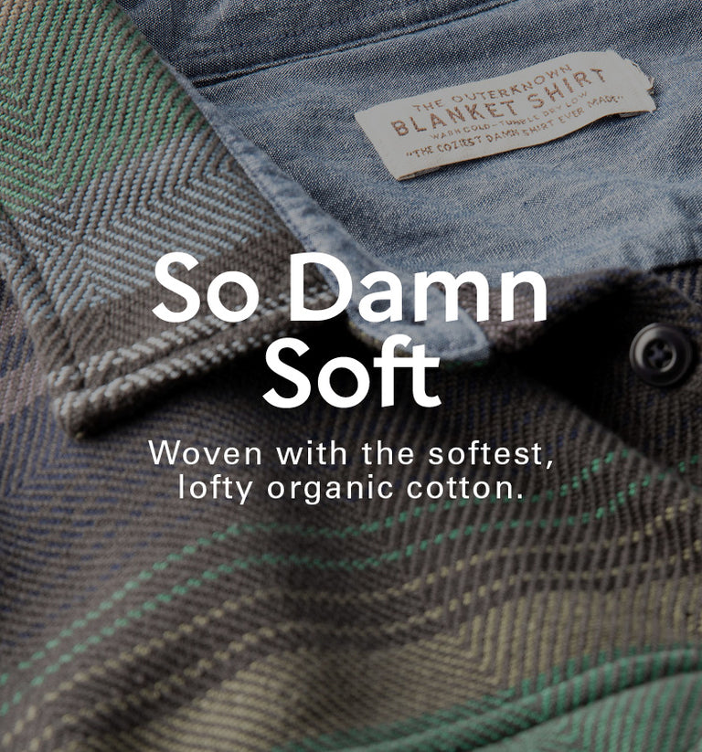 Textured fabric with a label and text 'So Damn Soft' on a plaid pattern.