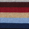 Striped fabric swatch with brown, red, beige, and blue colors.