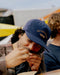 Blue 5-panel cord hat with OUTERKNOWN fish logo, side view