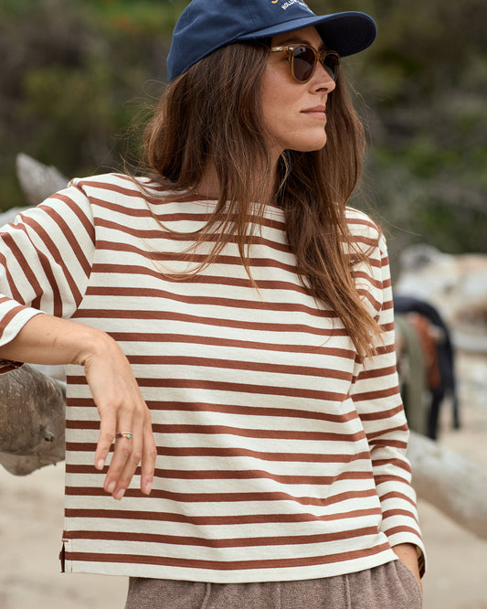 Woman wearing a striped shirt and cap outdoors