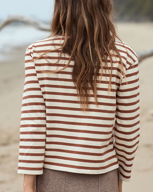 Person wearing a striped shirt with a blurred natural background