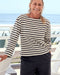 Person wearing a striped shirt and dark pants standing by a pool with a blurred background