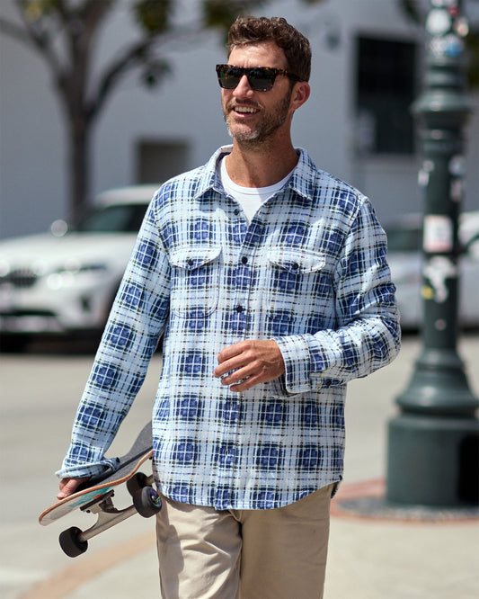 Man wearing a blue and white plaid blanket shirt.
