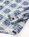 Closeup of sleeve of blue and white plaid blanket shirt.