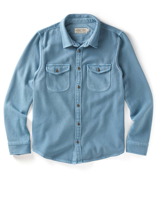 Blue blanket shirt with button details on a white background