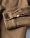 Detail of olive-brown blanket shirt cuff with brown buttons and stitching