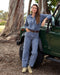 Woman standing next to a green jeep in a natural setting