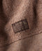Close-up of a brown textured fabric with an 'Outerknown' label.