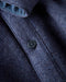 Close-up of a dark blue coat with a detailed button