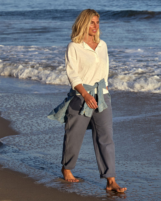 Woman walking on a beach with waves in the background