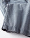 Close-up of a folded blue cord pants on white background