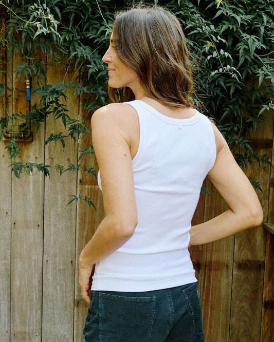 Woman wearing white tank top from the back