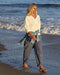 Woman walking on a beach with waves in the background