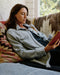 Woman reading a book on a patterned couch