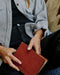 Person holding a red book with a blurred background