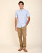 Men's chestnut stretch chino pants on model, straight legs with button closure